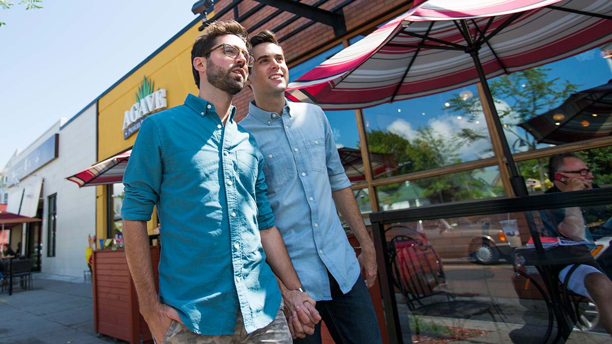 A couple walks hand-in-hand along Elmwood Avenue in Buffalo, NY