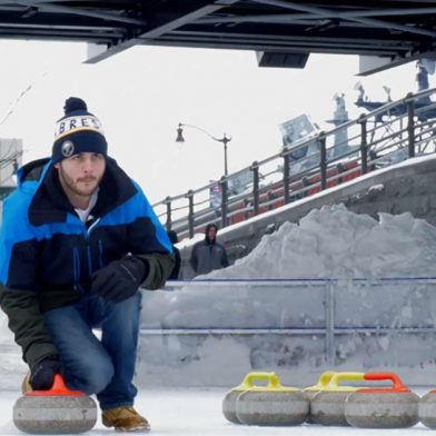 A man curling on an ice rink